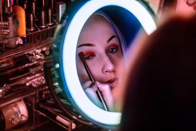 Woman Applying Makeup In the Mirror